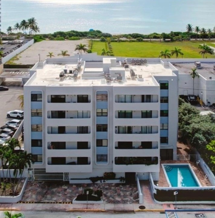 Aerial photo of Delkus Towers Condominium, 6725 Harding Avenue, Miami Beach, showing the pool, the building, and the ocean beyond